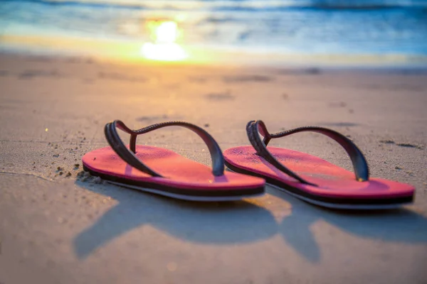 Sapato iluminado pela luz do sol na praia ao pôr do sol — Fotografia de Stock
