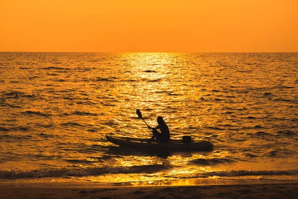 Fisherman are boating on sea in sunset — Stock Photo, Image