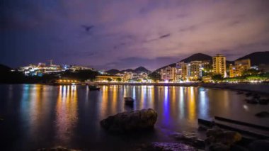 Zaman atlamalı, bulutlu geceleri Stanley Bay insanlar yürümeye ve dışarı el feneri Hong Kong. 