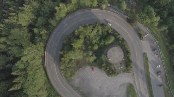 Aerial view of mountain road turn around with car driving along — Stock Video