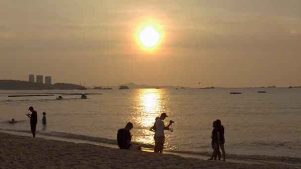 PATTAYA, TAILANDIA - FEBRERO 2016: personas pasando el rato en la playa al atardecer en Pattaya, Tailandia — Vídeos de Stock