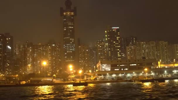 Passeio de barco com vista noturna de edifícios altos ao longo da costa em uma noite nebulosa — Vídeo de Stock