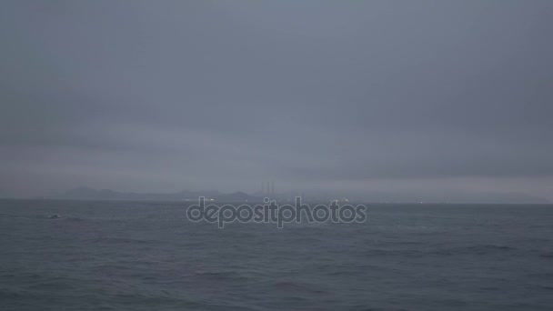 Passeio de barco no oceano em um dia nublado tempestuoso com a ilha no fundo em uma noite nebulosa — Vídeo de Stock