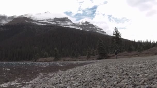 Viajante olhando com binocular nas Montanhas Rochosas canadenses — Vídeo de Stock