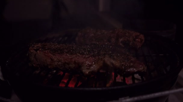 Красивое пламя, жгущее один стейк на барбекю — стоковое видео