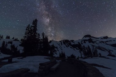 Karlı dağın üzerinde yıldızlı gece gökyüzü
