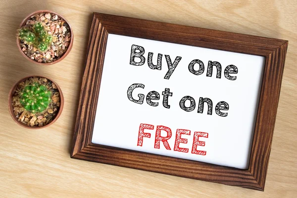 buy one get one free, text message on wood frame board on wood table / business concept / Top view