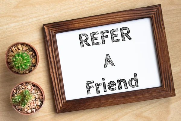 Refer a friend, text message on wood frame board on wood table / business concept / Top view — Stock Photo, Image