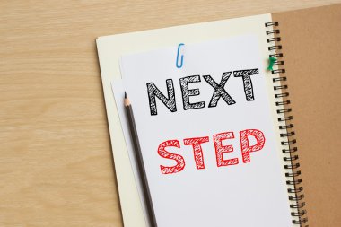 Sonraki adım kısa mesaj beyaz kağıt kayda masanın üstüne / iş kavramı