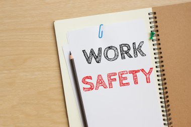 Text work safety on white paper and pencil on the desk / top view / business concept