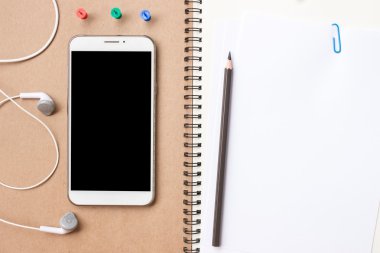 notebook with phone. notepad and keyboard, top view with mobile device on wooden desk. mock up