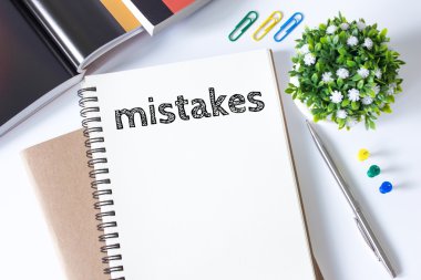 mistakes word message on white paper book and copy space on white desk / business concept / top view clipart