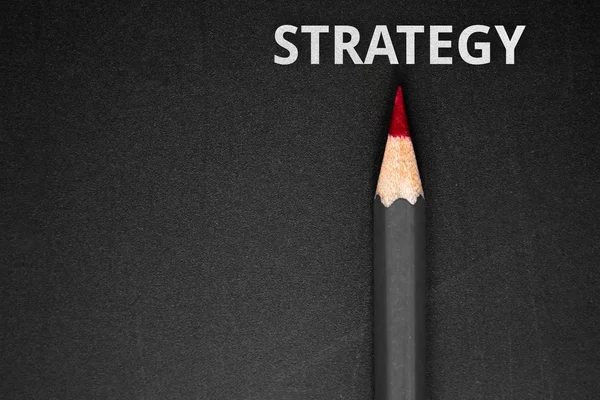 De strategie van de tekst met potlood op zwarte achtergrond / bedrijfsconcept — Stockfoto