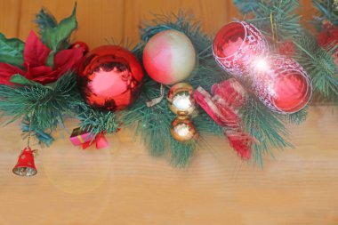 Ahşap döşeme üzerine Noel süslemeleriyle süslenmiş ladin dalı.