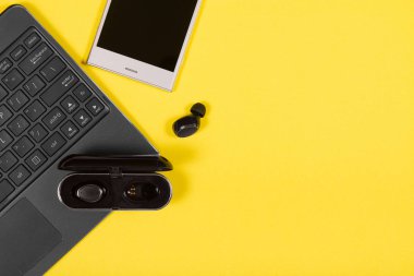 Laptop, akıllı telefon, şarj çantası ve kablosuz kulaklık.