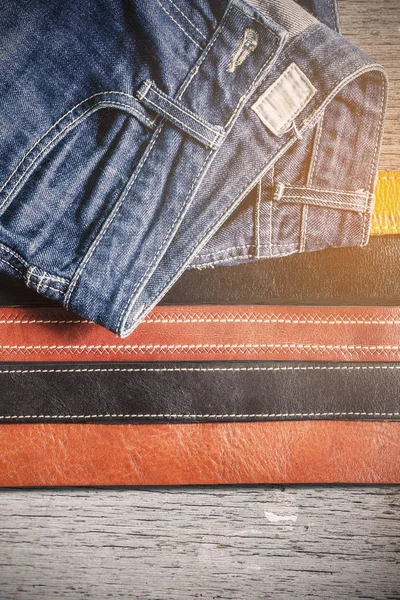 Jeans and belts on wooden. — Stock Photo, Image
