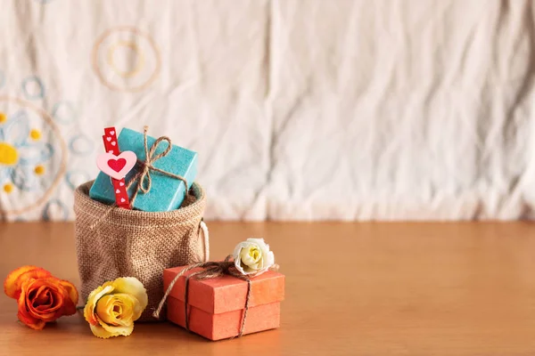 Regalo y rosas en un suelo de madera . — Foto de Stock