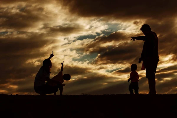 Ouders en kinderen bij zonsondergang. — Stockfoto