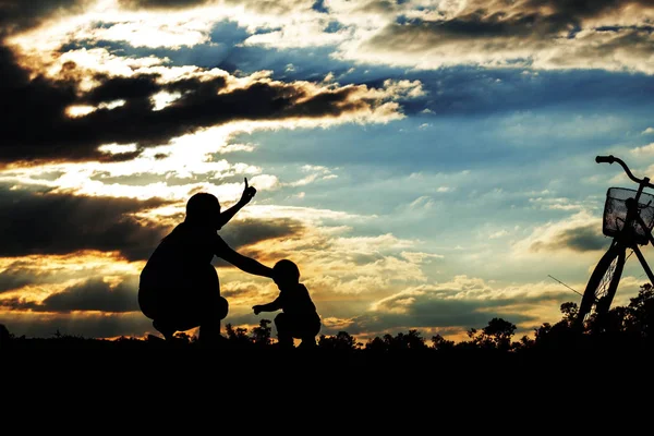 Moeder en kind bij zonsondergang. — Stockfoto