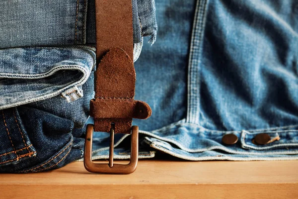 Cinturón viejo y jeans en madera . —  Fotos de Stock