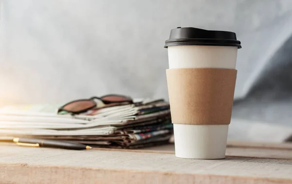 Koffie en kranten op houten vloer. — Stockfoto