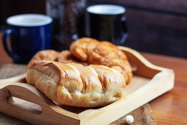 Bröd och cup på bord. — Stockfoto