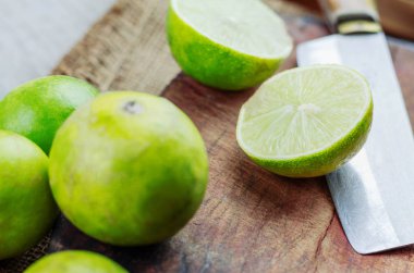 Taze limon yarısı ve bıçak kesim ahşap zemin üzerinde.