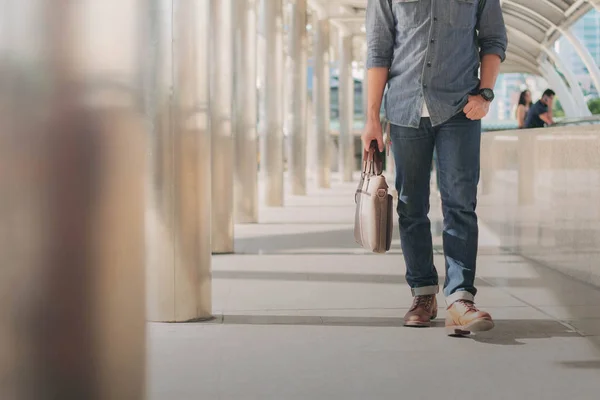 Hombre con jeans azules caminando por la ciudad . — Foto de Stock