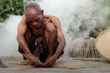 Old man is weaving baskets.