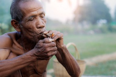 Old men are smoking cigarettes.