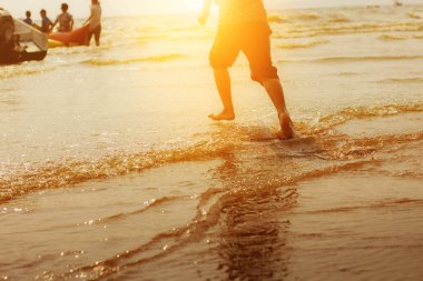 Çocuk güneş ışığıyla yelkenlide koşuyor..