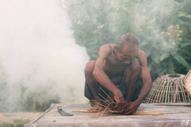 Asyalı erkekler Tayland kırsalında bambu sepetleri dokuyorlar..