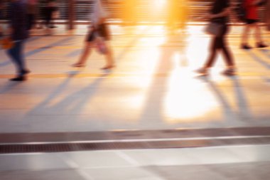 İnsanlar şehirde günbatımında yürüyor.