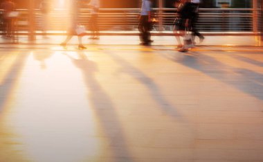 İnsanlar bulanıklık görüntü ile gün batımında yürüyor.