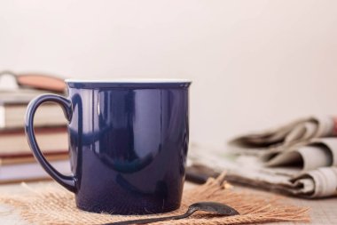 Eski ahşap zeminde bir fincan kahve ve kitaplar..