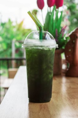 Restorandaki ahşap masada yeşil çay bardağı..