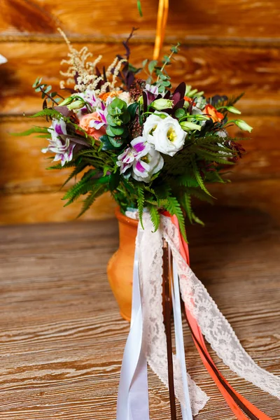 Яркий свадебный букет с лентами, стоящими в глиняном кувшине на — стоковое фото