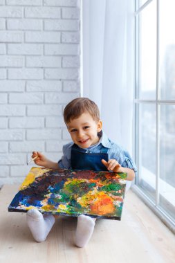 Sevimli, mutlu, beyaz oğlan mavi tişört ve kot Rüzgar oturan