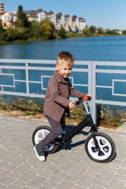 Mutlu dört yaşında çocuk binicilik bisiklet pedalları olmadan ba