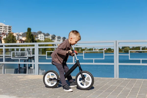 Feliz menino de quatro anos andando de bicicleta sem pedais na ba — Fotografia de Stock