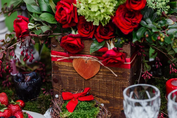 Γάμος διακόσμηση Πίνακας: λουλούδια σύνθεση με τριαντάφυλλα, μούρα, βότανα και πράσινο στέκεται σε ξύλινο κουτί. Νυφικό λεπτομέρειες και διακοσμήσεις, Ρομαντικό δείπνο στο δάσος — Φωτογραφία Αρχείου