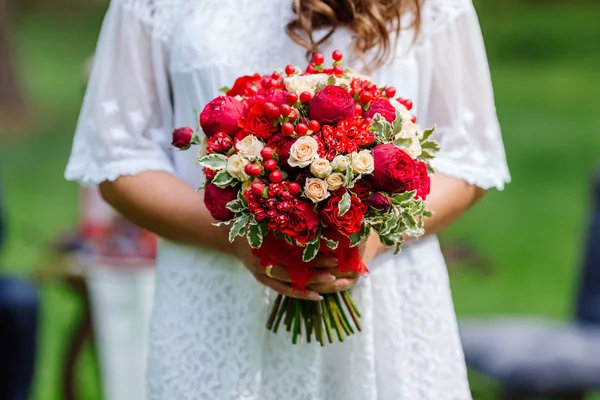 Невеста в белом платье, держа в руках нежный, дорогой, модный свадебный букет цветов в марсале и красных тонах. Закрыть, вид сверху — стоковое фото