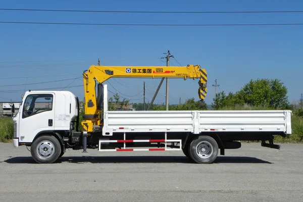 Weißer Isuzu-Tieflader mit gelbem Kranarm steht auf dem Parkplatz - Russland, Moskau, 30. August 2016 — Stockfoto