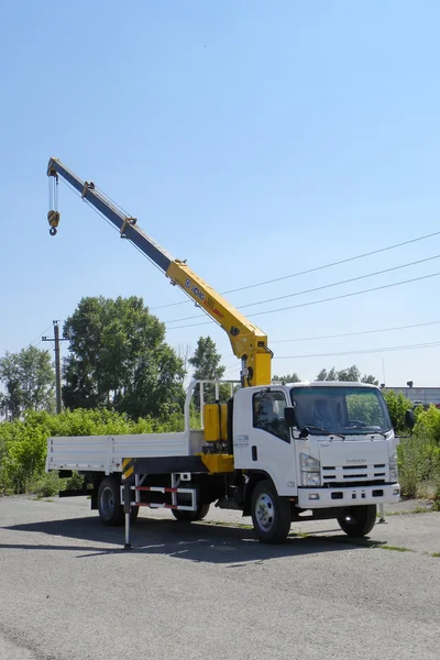 Weißer Isuzu-Tieflader mit gelbem Kranarm steht auf dem Parkplatz - Russland, Moskau, 30. August 2016 — Stockfoto