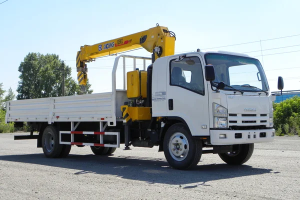 Camión plano Isuzu blanco con brazo de grúa amarilla está en el estacionamiento - Rusia, Moscú, 30 de agosto de 2016 —  Fotos de Stock