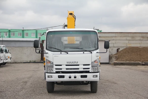 Weißer Isuzu-Tieflader mit gelbem Kranarm steht auf dem Parkplatz - Russland, Moskau, 30. September 2016 — Stockfoto