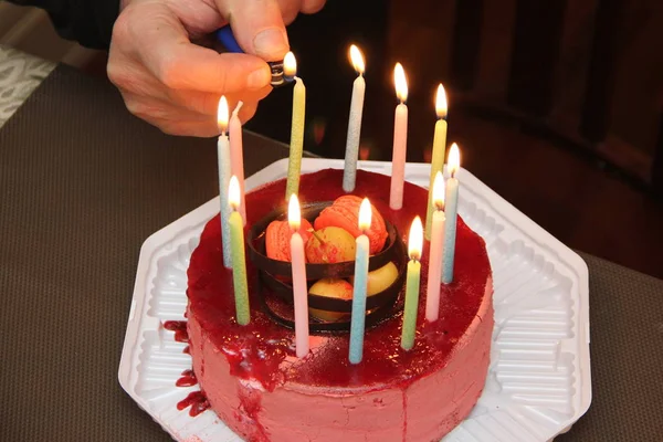 Torta di compleanno con candele accese in mano — Foto Stock