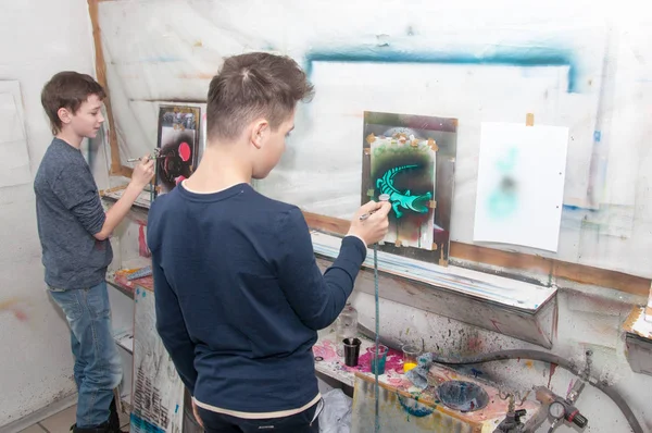 Gruppe von Kindern Teenager malen mit einer Airbrushfarbe bunte Bilder in einem künstlerischen Atelier - Russland, Moskau - 24. Januar 2016 — Stockfoto