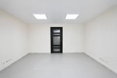 Vnitřní prázdnou kancelář světlé místnosti s bílým tapety nezařízený v nové budově