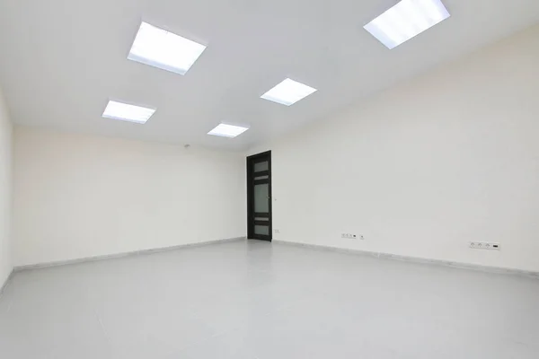 Yeni bir binada mobilyasız beyaz duvar kağıdı ile iç boş ofis ışık Oda